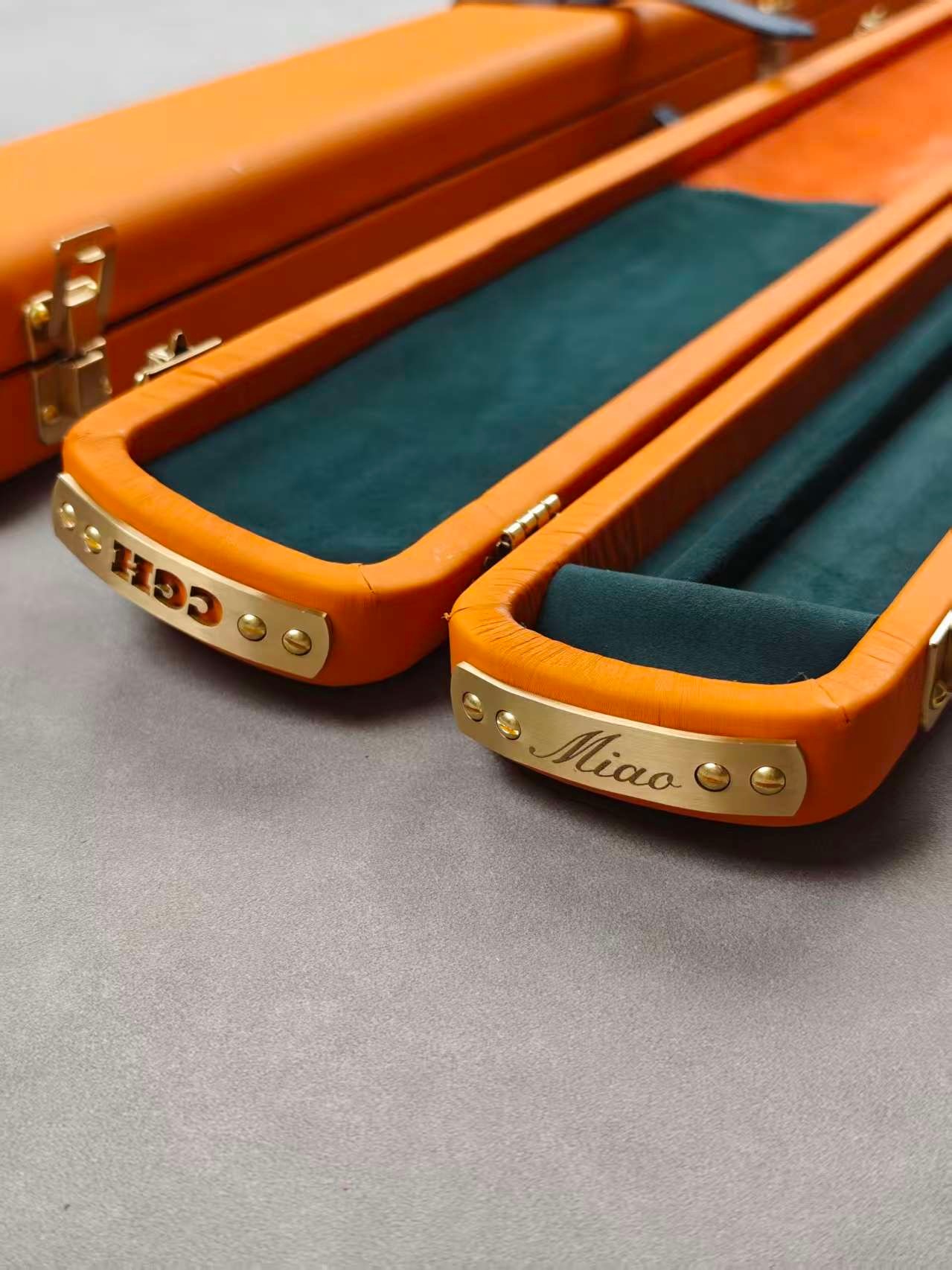 Close-up of orange leather, green case lining and personalised metal plates